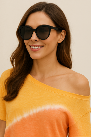 Close-up of woman in Democracy orange and yellow tie-dye tee with off-the-shoulder neckline, styled with black sunglasses for a trendy summer vibe.