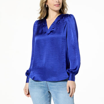 Front view of DG2 by Diane Gilman satin V-neck puff-sleeve blouse in royal blue, styled with light denim jeans.