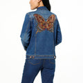  Woman modeling the back of the DG2 embroidered denim jacket, highlighting the vibrant butterfly motif and classic jean jacket cut.