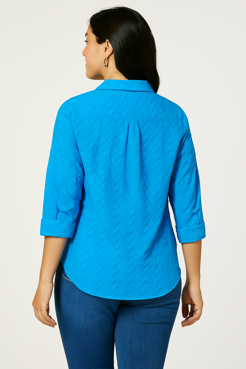 Back view of the Jaclyn Smith Embroidered Cotton Voile Buttoned Shirt in bright blue, featuring a chevron texture and 3/4-length sleeves, styled with medium-wash denim jeans.
