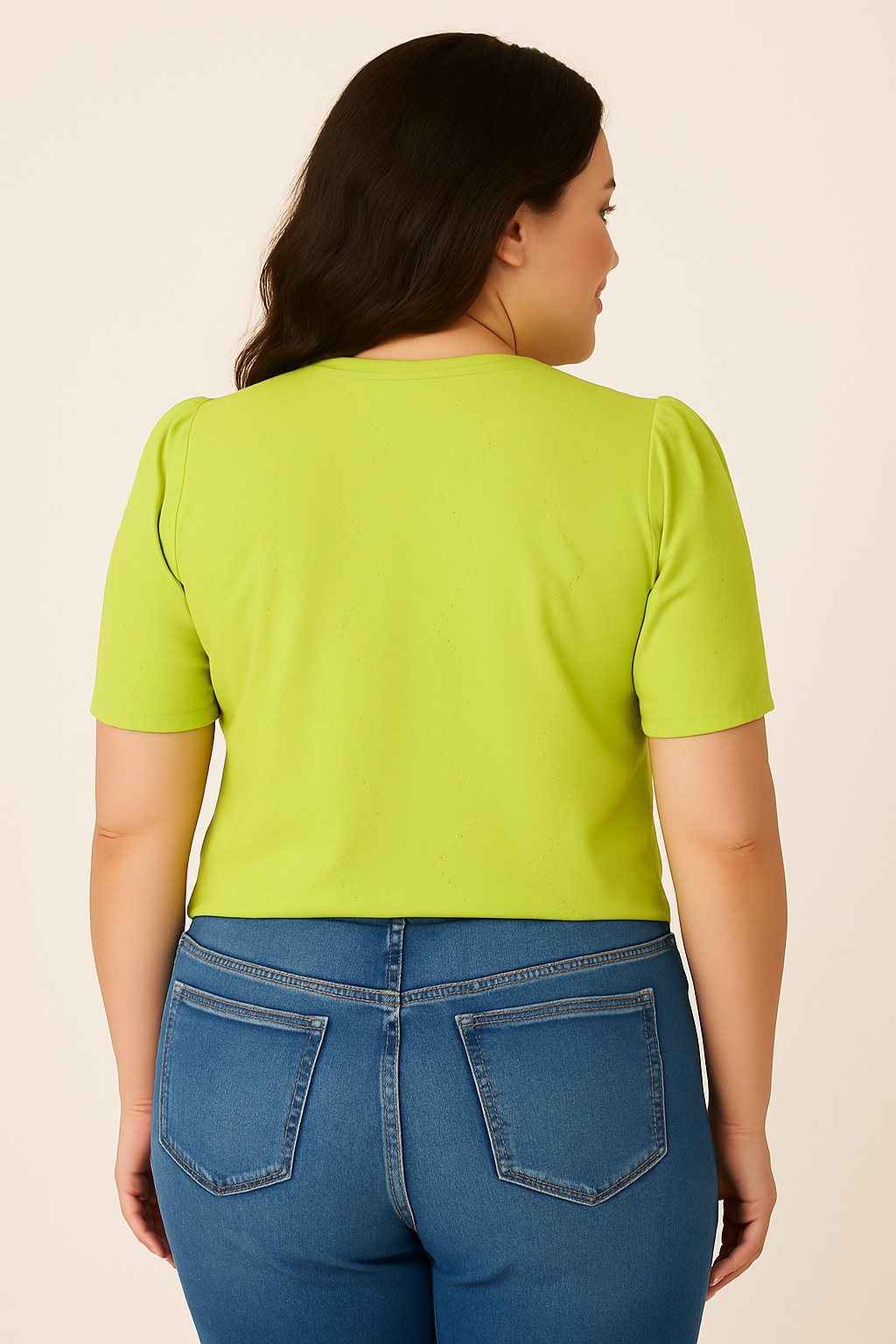 back view of a plus-size woman in a Jaclyn Smith Eyelet Knit Puff Sleeve Tee in bright lime green, paired with medium blue denim jeans. The soft fabric and delicate eyelet pattern add a touch of elegance.