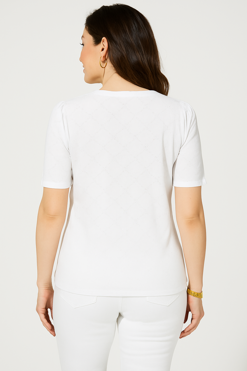 Back view of a woman wearing a Jaclyn Smith Eyelet Knit Puff Sleeve Tee in white, paired with matching white pants. The delicate eyelet pattern is subtly visible against the white fabric, captured in soft, even lighting.
