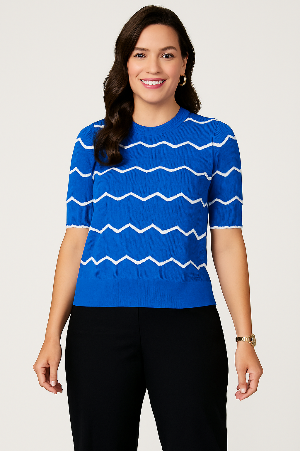 Jaclyn Smith Short-Sleeve Chevron Knit Sweater in bright blue with white chevron stripes, styled with classic black pants, accessorized with gold hoop earrings and a gold watch for a semi-formal look.

